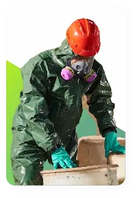 Industrial worker wearing lakeland industries chemical suit to protect against chemicals in a barrel that they are inspecting