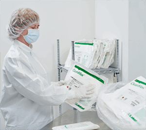 Worker organizing medical supplies on shelves.