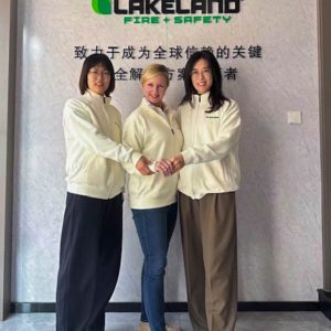 Three women posing in front of Lakeland Fire Safety sign.