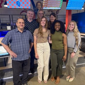 Group of people smiling at a bowling alley.