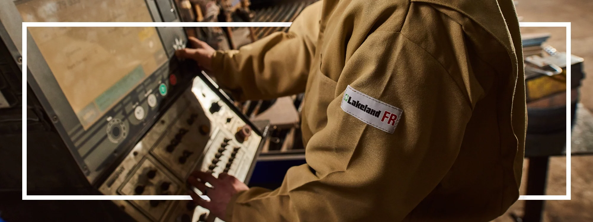 Image of Lakeland FR coveralls being worn by a factory worker operating heavy machinery