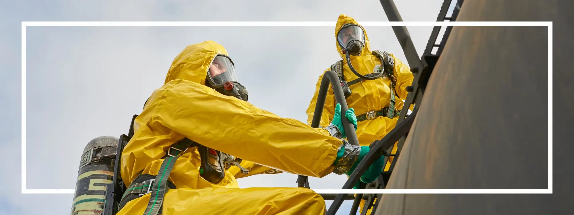 Two workers donned in ChemMax chemical protection cleaning large oil tanks