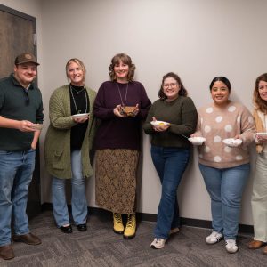 Group standing with bowls in an office.