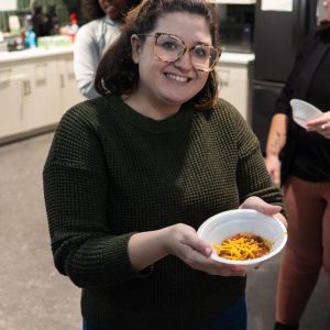 Smiling woman holding a bowl of chili.