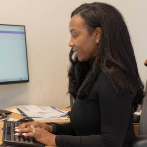 Woman typing on a computer at her desk.
