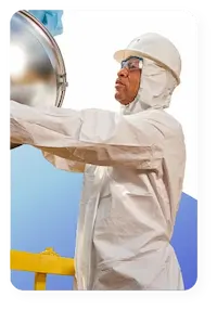 Industrial worker wearing disposable coveralls from lakeland industries to keep protected while working in a dangerous environment