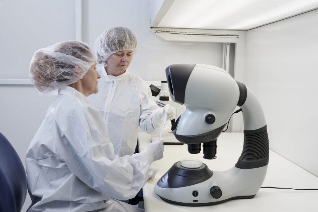 Scientists using microscope in laboratory setting.