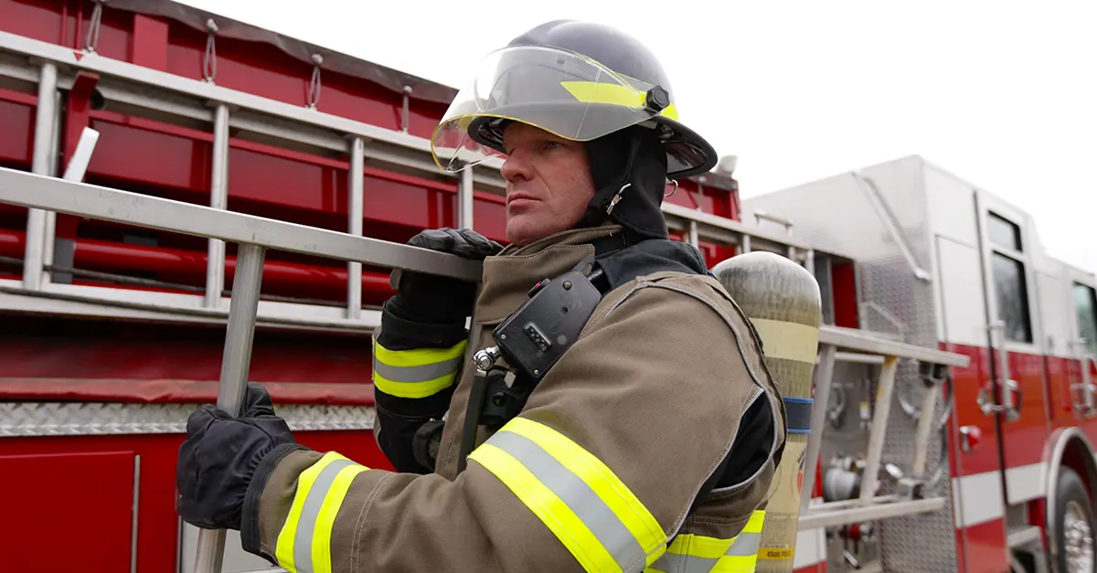 Fireman carrying ladder wearing Lakeland Firegear